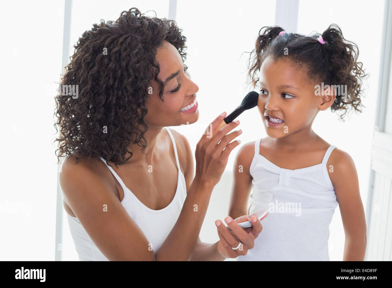 Jolie mère sa fille d'enseignement sur un miroir Banque D'Images