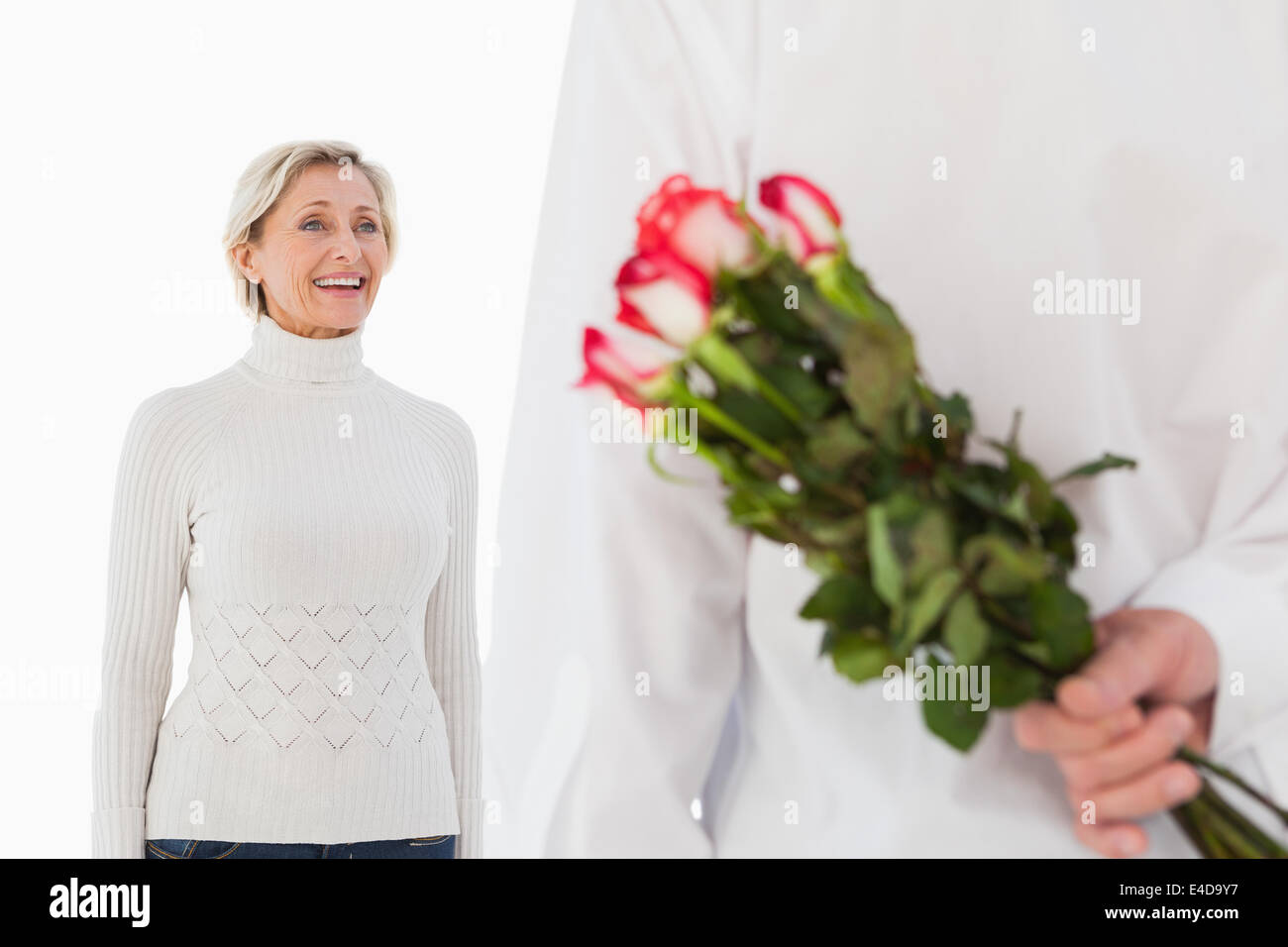 Man hiding bouquet de roses à partir de la femme plus âgée Banque D'Images
