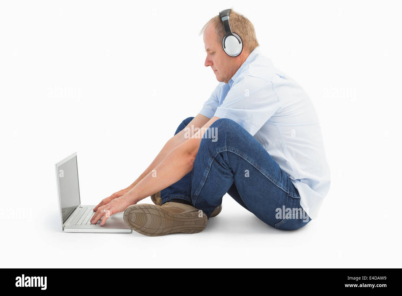 Mature man using laptop à écouter de la musique Banque D'Images