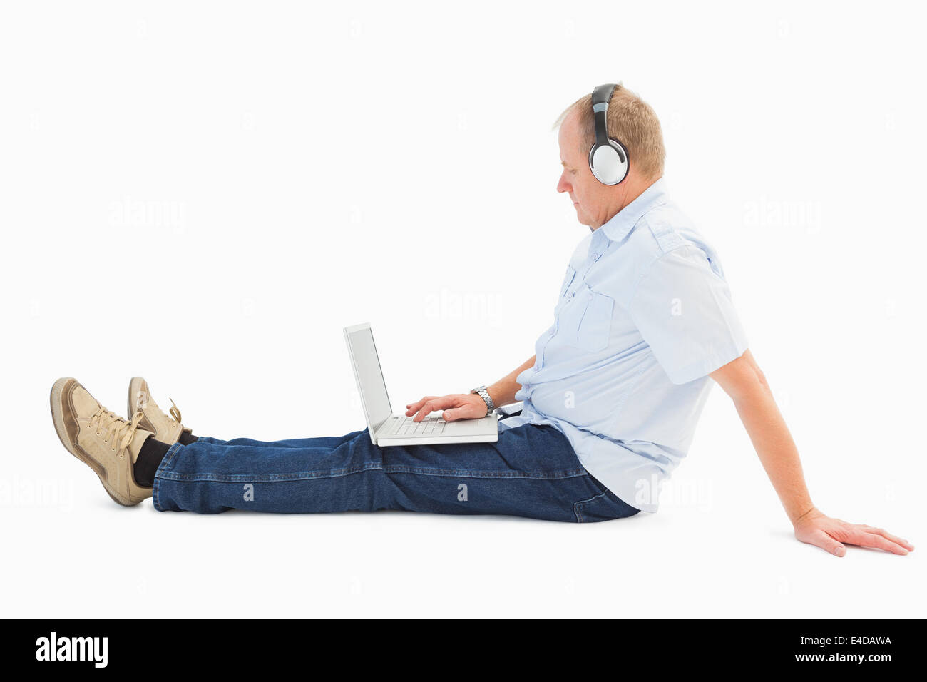 Mature man using laptop à écouter de la musique Banque D'Images