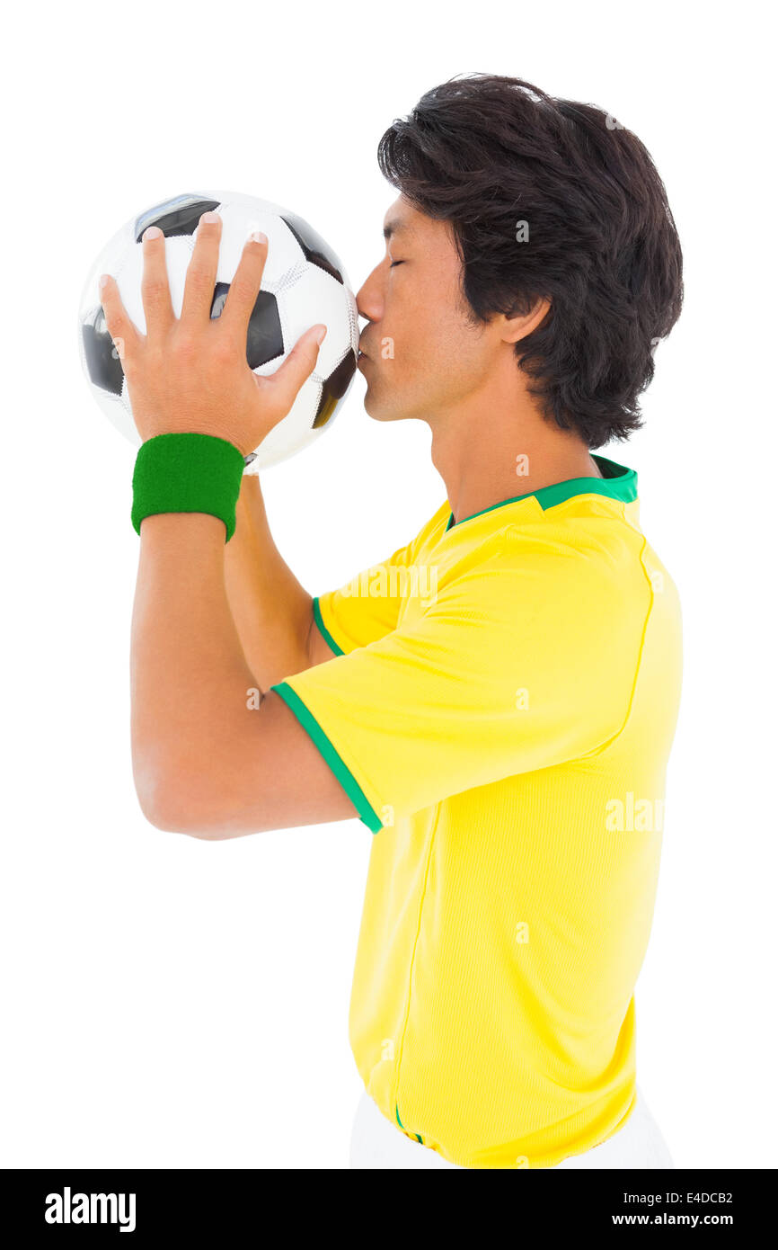 Joueur de football en jaune kissing ball Banque D'Images