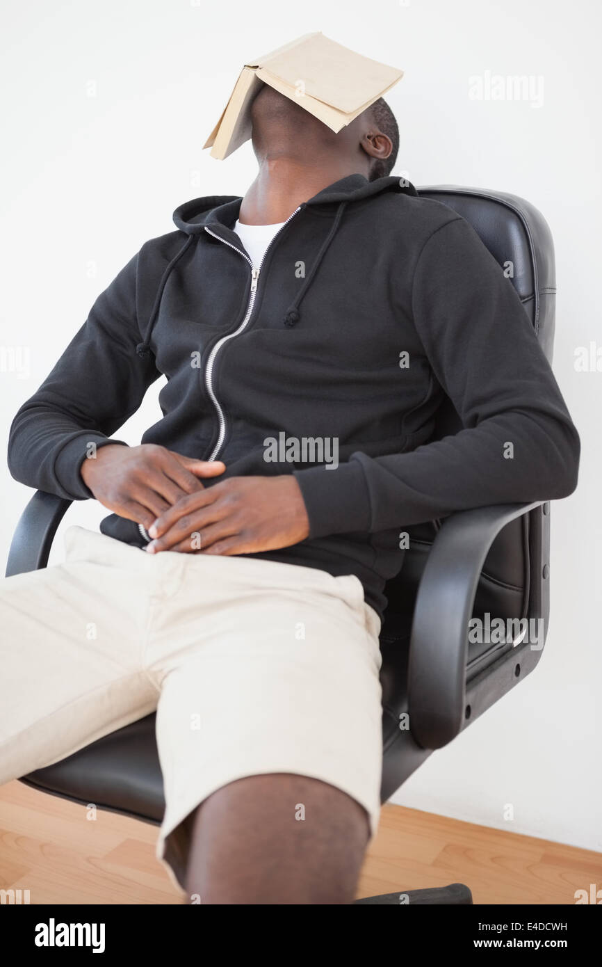 Casual man pointing livre sur le visage Banque D'Images