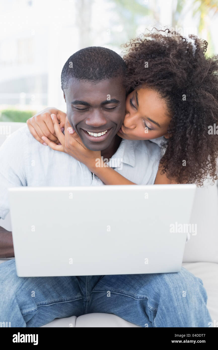 Beau couple using laptop together on sofa Banque D'Images