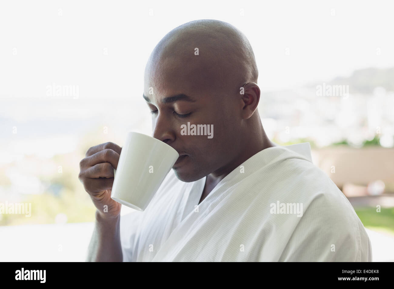 Bel homme en peignoir de boire du café à l'extérieur Banque D'Images