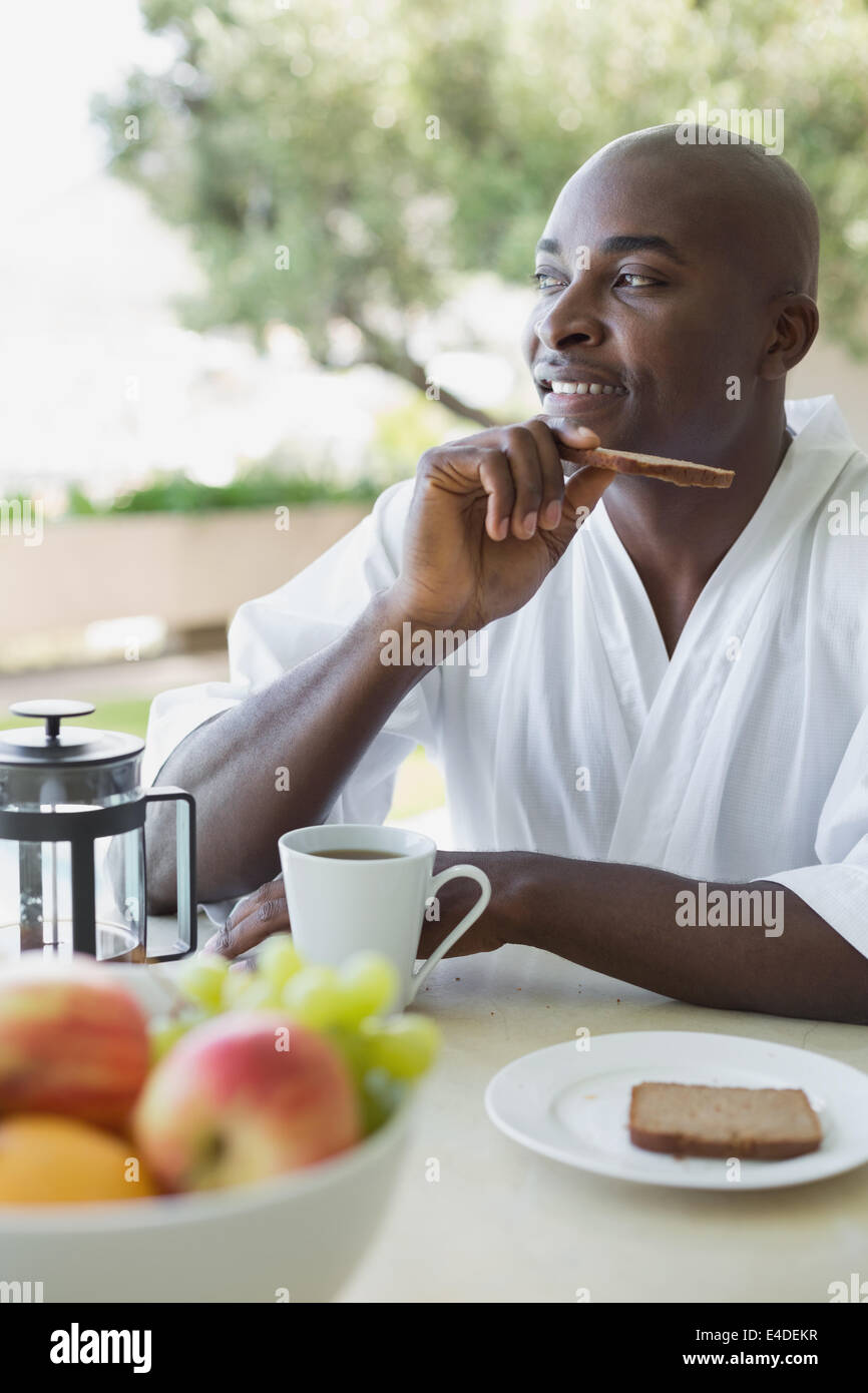 Bel homme en peignoir de prendre le petit déjeuner à l'extérieur Banque D'Images