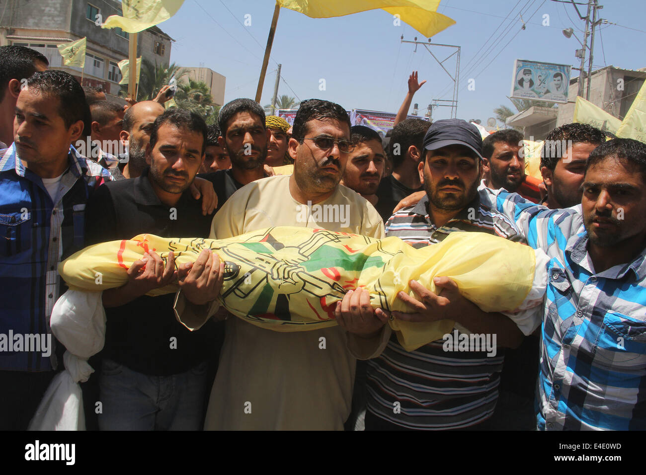 La bande de Gaza. 09 juillet 2014. Les gens portent le corps de la famille Kaware lors des funérailles dans le sud de la bande de Gaza ville de Khan Younis, le 9 juillet 2014. Le père, un membre du mouvement Fatah, et ses 6 jeunes fils ont tous été tués par une frappe aérienne israélienne visant leur maison. L'air israélienne a bombardé des cibles 160 dans la bande de Gaza pendant la nuit qu'il a appuyé sur une vaste campagne pour arrêter volées de tirs de roquettes palestiniens, un fonctionnaire a déclaré l'armée. Au moins 27 personnes ont été tuées depuis le début des attaques israéliennes dans l'enclave. Source : Xinhua/Alamy Live News Banque D'Images