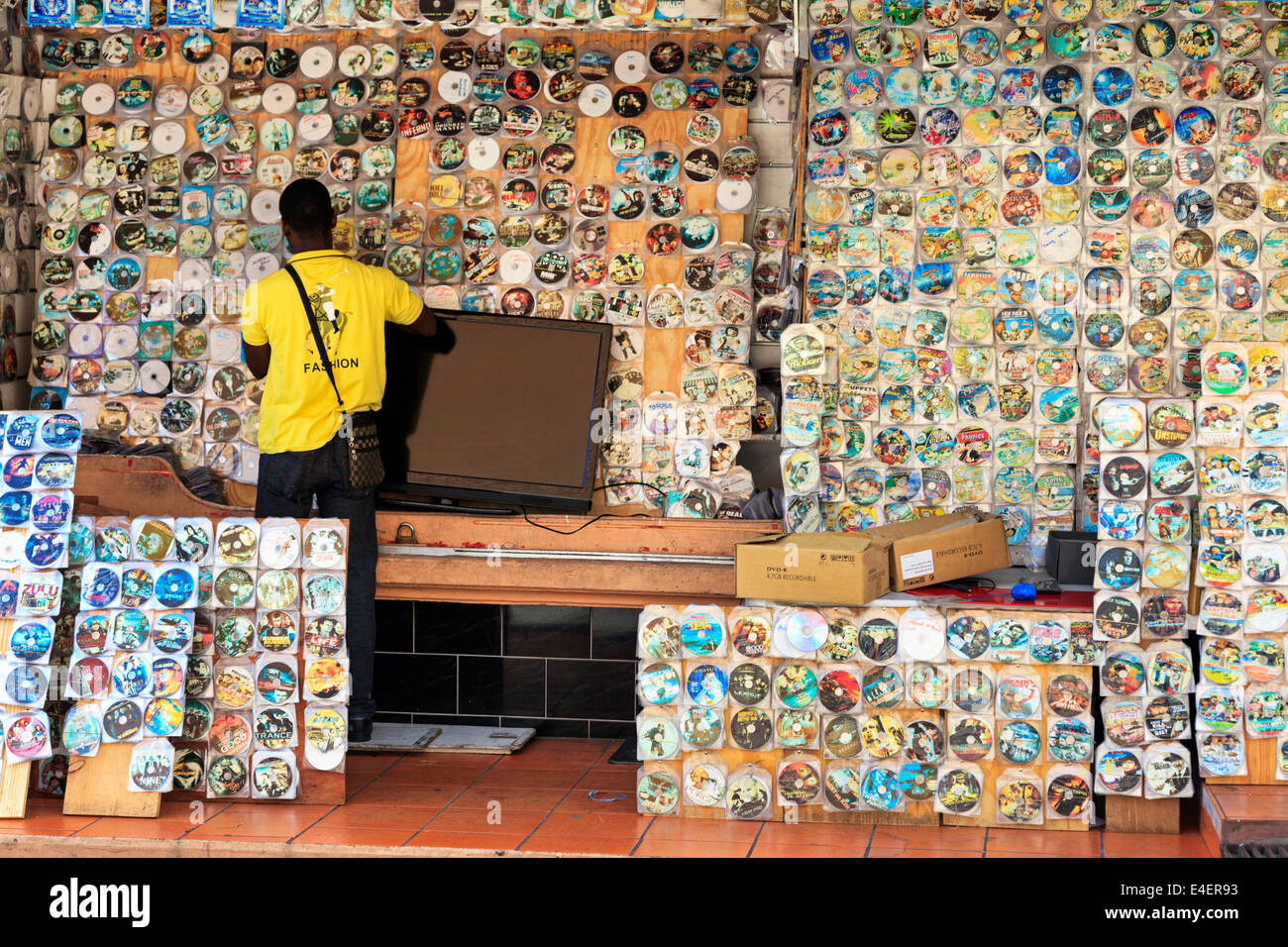 L'homme de vendre le piratage de DVD et de CD à partir d'un étal de St George, la Grenade, dans les Antilles. Banque D'Images