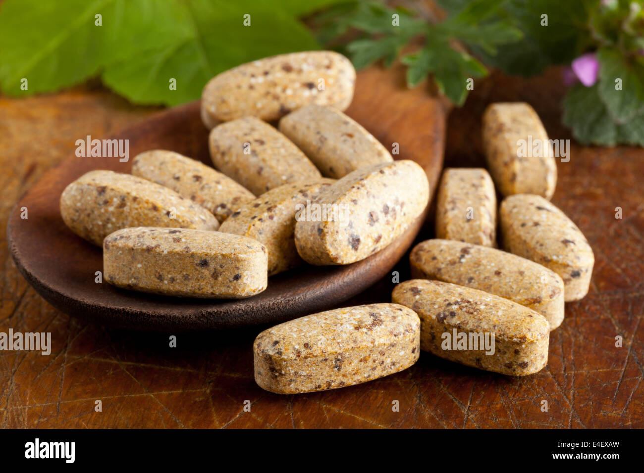 Supplément de vitamine d'herbes et des herbes sur des pilules avec cuillère en bois Banque D'Images