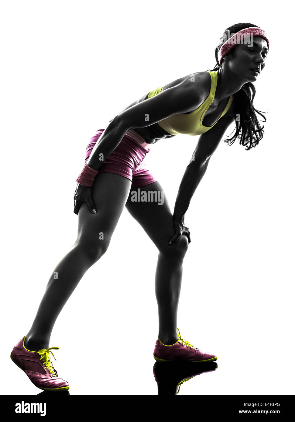 Une femme runner exécutant une crampe musculaire douleur en silhouette sur fond blanc Banque D'Images