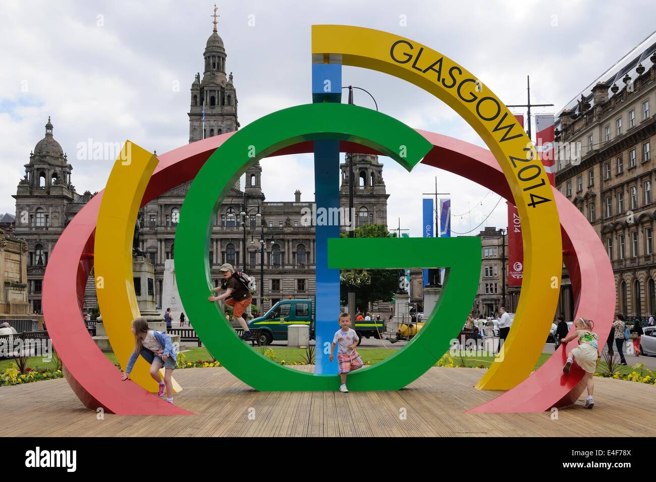Les enfants jouent sur le logo des Jeux du Commonwealth 2014 à Glasgow dans George Square Banque D'Images