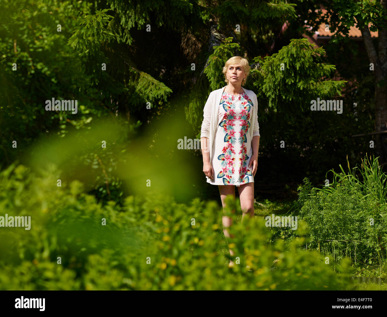 Belle femme mature dans un jardin ensoleillé, summerday Banque D'Images