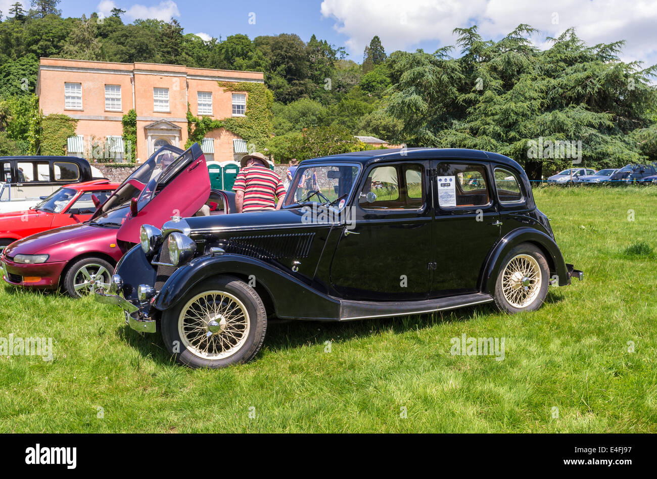 L'est du Devon, Angleterre. Un 1936 Riley Adelphi 12/4 lors d'une fete et garden party en face de la maison de campagne avec d'autres voitures classiques. Banque D'Images