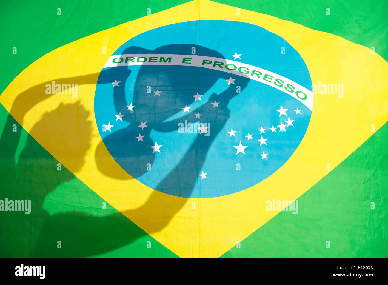 Ombre de fête brésilienne avec trophy au soleil contre drapeau brésilien Banque D'Images