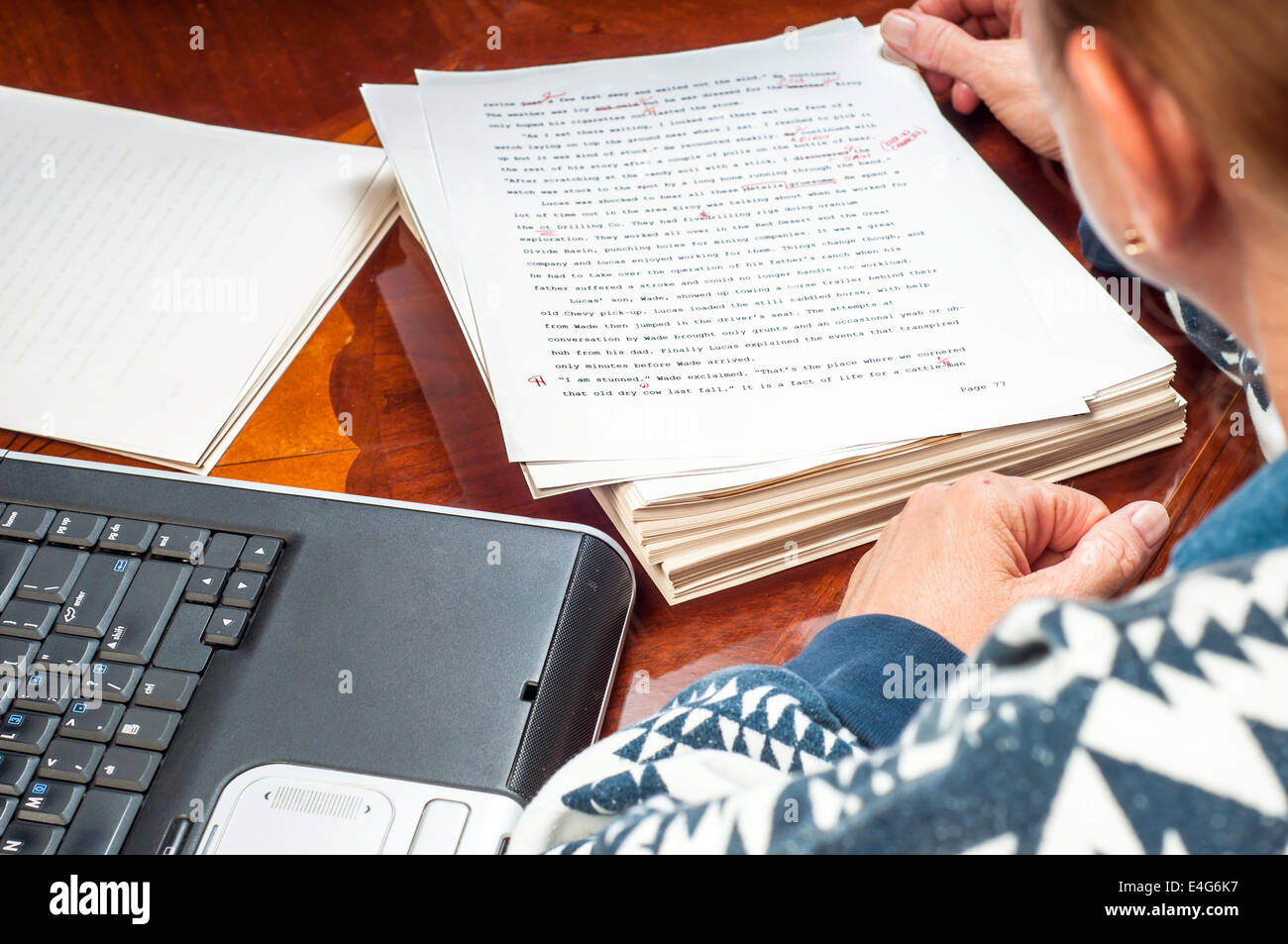 Femme auteur re-écrit son manuscrit après qu'il a été relu par un éditeur. Banque D'Images