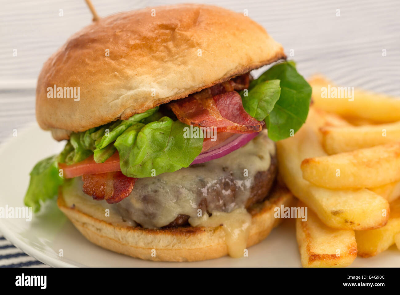 Cheeseburger et des frites avec un petit pain brioché - studio abattu avec une faible profondeur de champ Banque D'Images