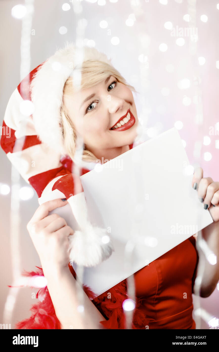 Jeune femme en costume père noël holding liste vide de voeux Banque D'Images