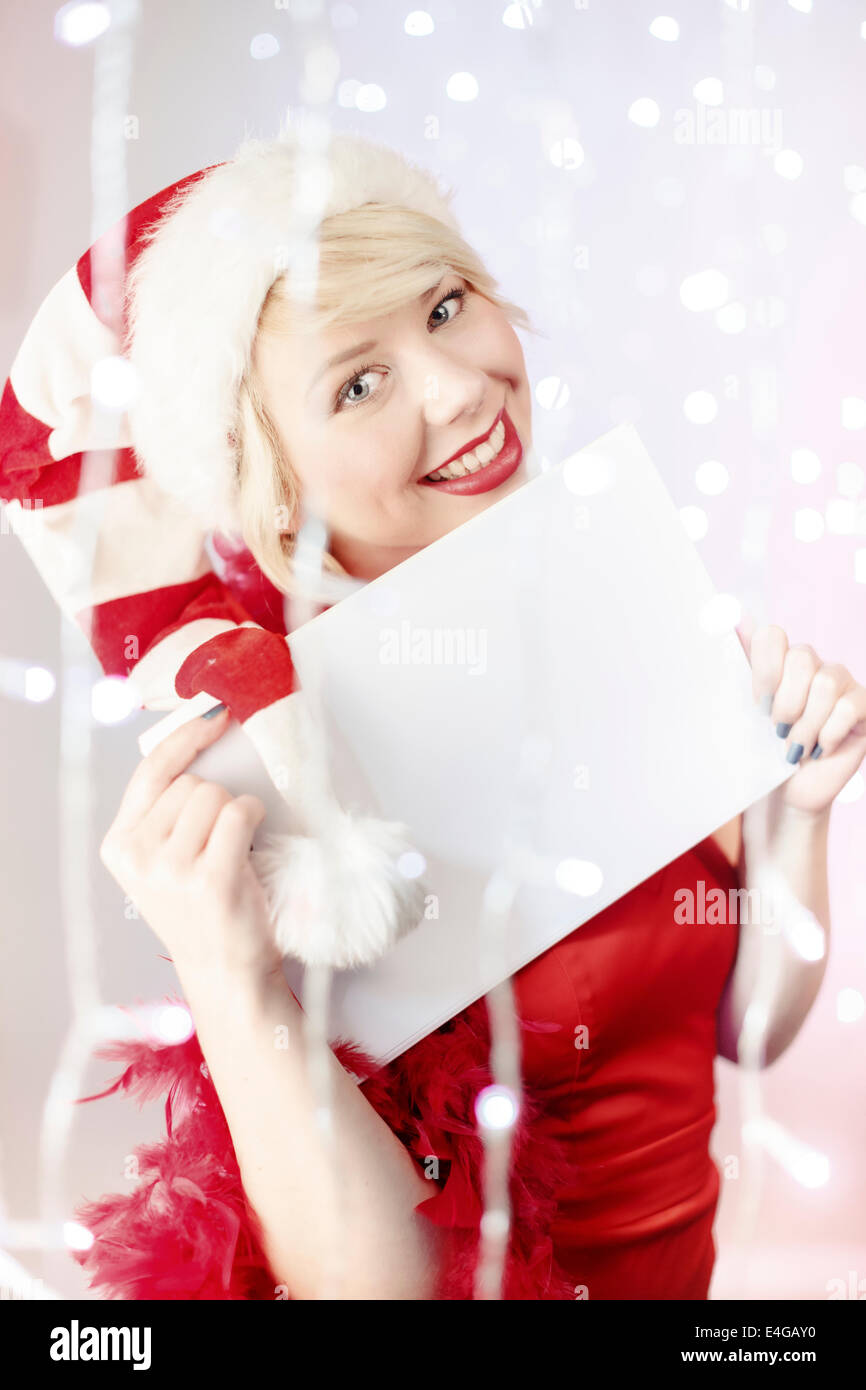 Jeune femme en costume père noël holding liste vide de voeux Banque D'Images