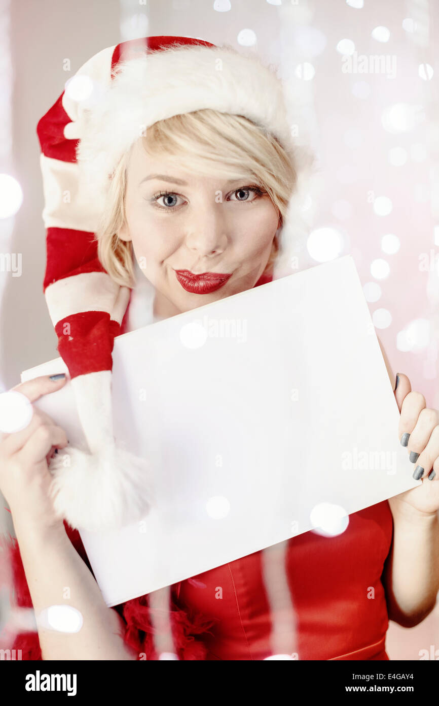 Jeune femme en costume père noël holding liste vide de voeux Banque D'Images