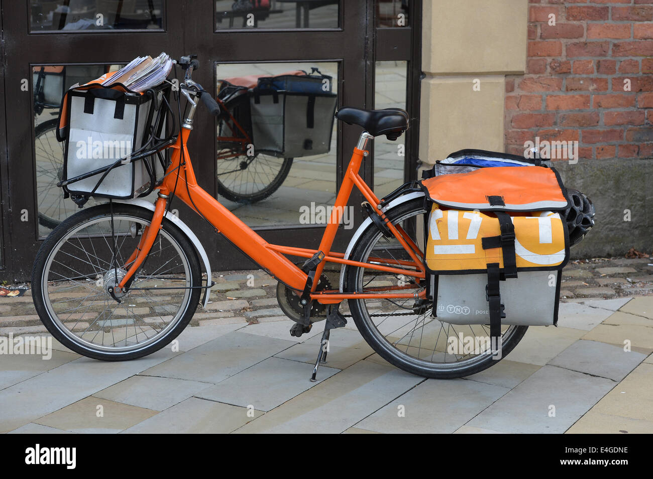 Un service de TNT post vélo orange dans le centre-ville de Manchester. Banque D'Images