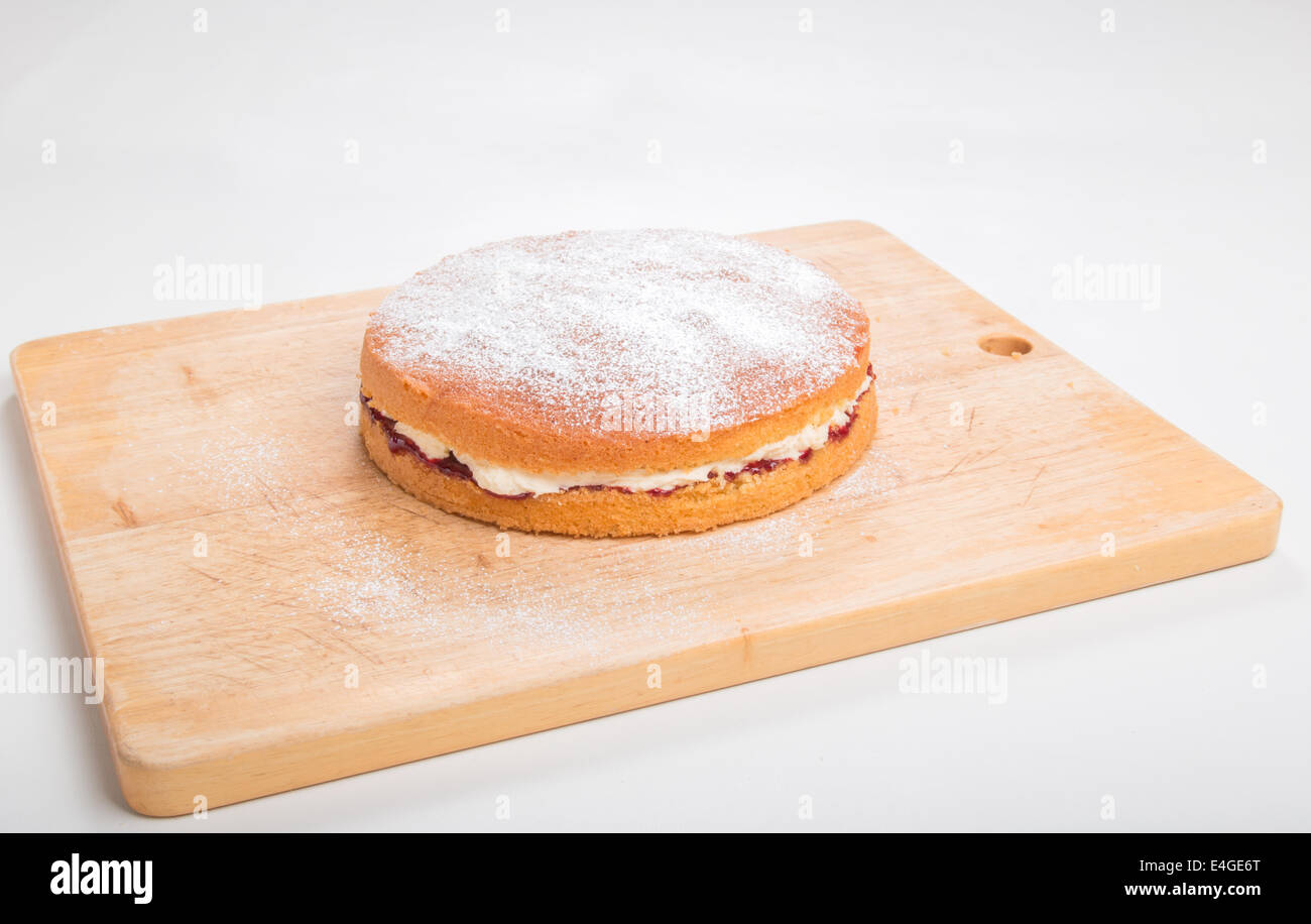 Victoria sponge cake rempli de confiture et beurre Crème fraîche saupoudrée de sucre glace sur une planche en bois 'out' (38 de 44) Banque D'Images