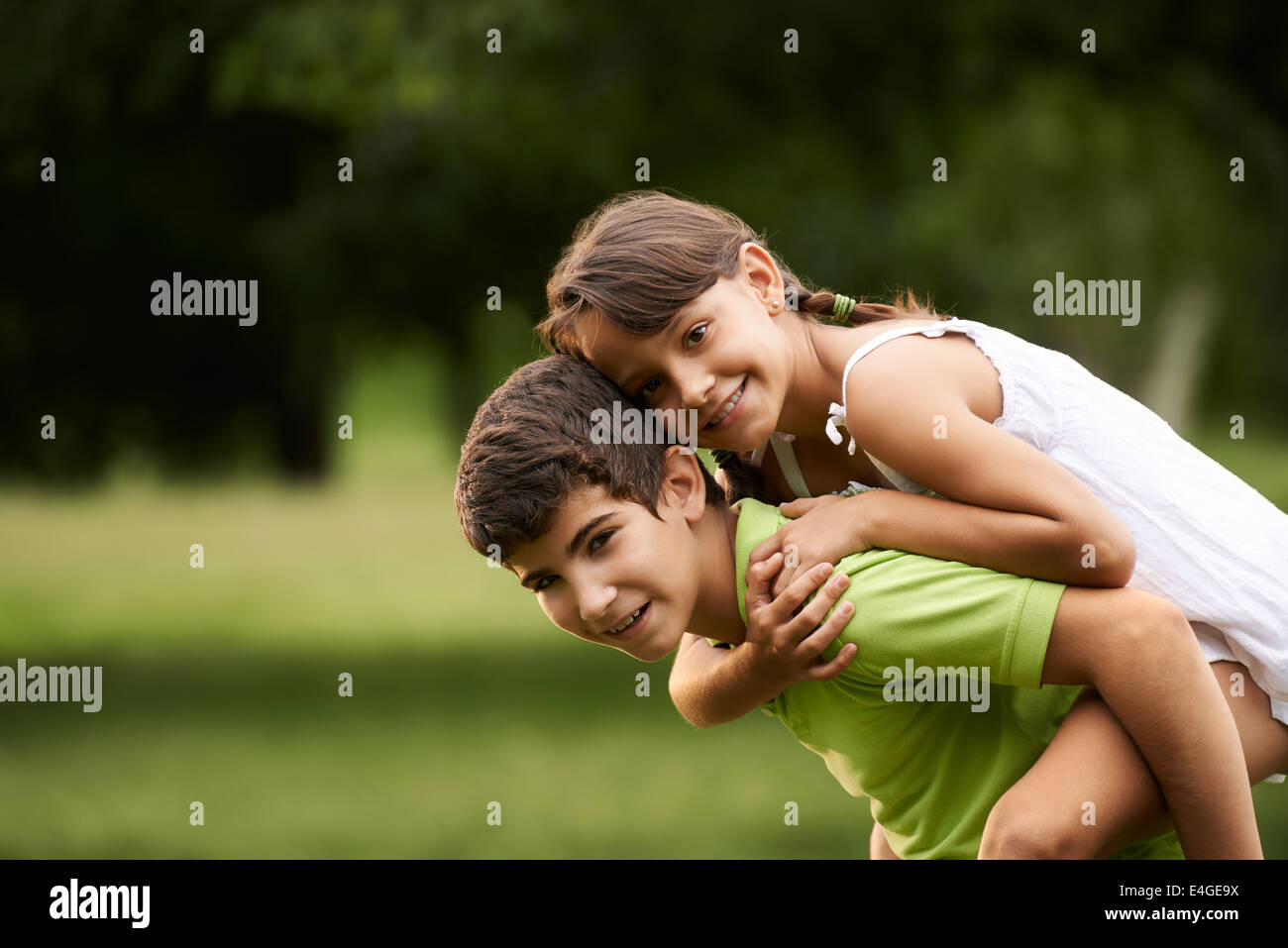 Les gens dans l'amour avec happy little girl and boy running s'y greffent en parc de ville. Copy space Banque D'Images