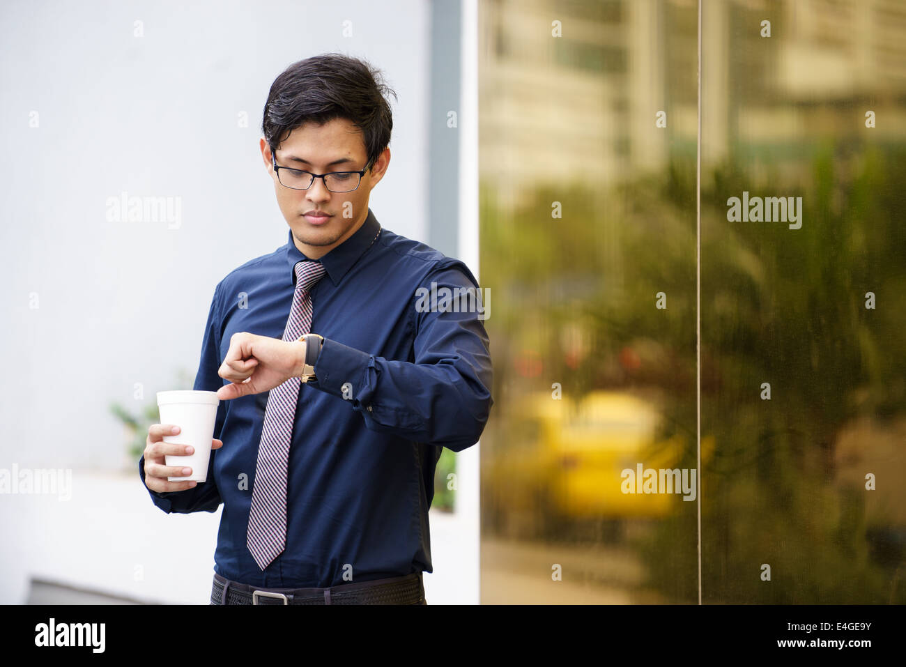 Portrait de chinese man building au Panama avec tasse à café et contrôle du temps à regarder Banque D'Images