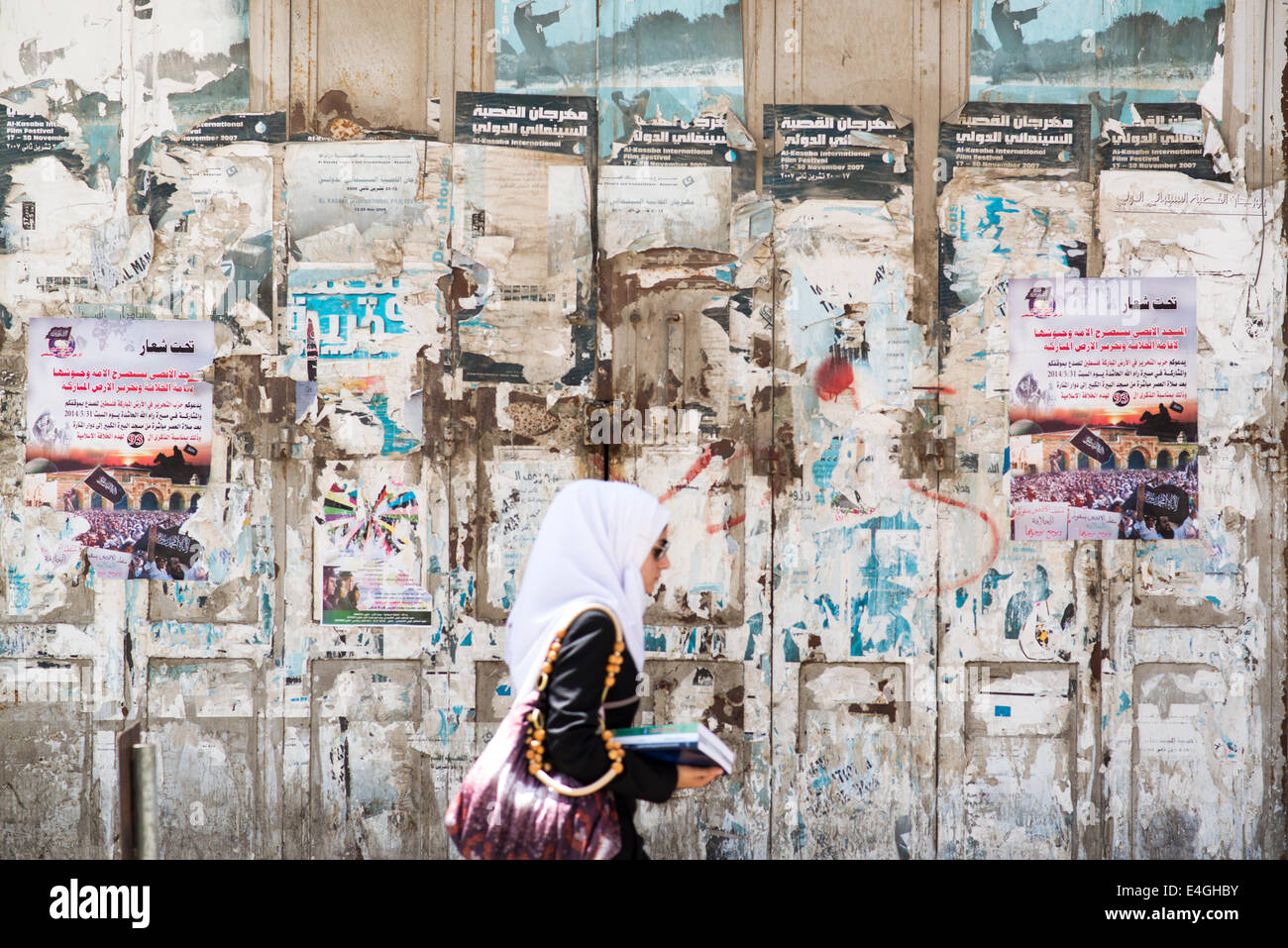 Ramallah. 10 juillet, 2014. Une femme palestinienne va à ses occupations quotidiennes comme d'habitude dans le centre commercial de la place Al-Manara. Les manifestations ont été éclatent dans la région en réaction au récent conflit avec Israël. Kevin Su/Alamy Live News Banque D'Images