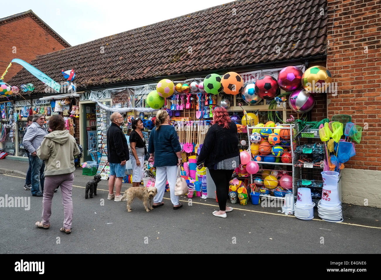 Les touristes d'acheter des éléments d'une boutique vendant des jouets de plage et des nouveautés. Banque D'Images