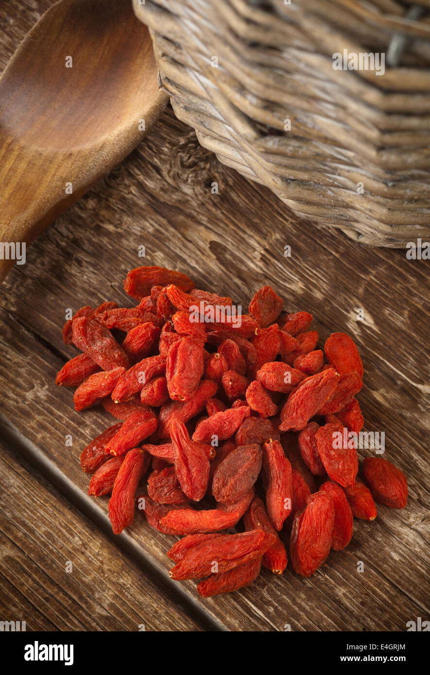 Baies de goji séchées isolé sur table en bois. Banque D'Images