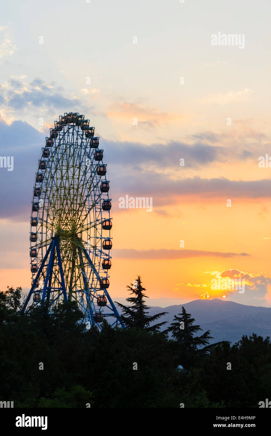 Grande roue au coucher du soleil. Mtatsminda amusement park Banque D'Images