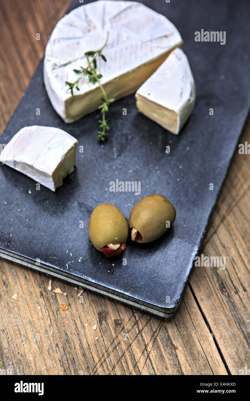 Nature morte avec assiette de fromage et les olives sur la table Banque D'Images