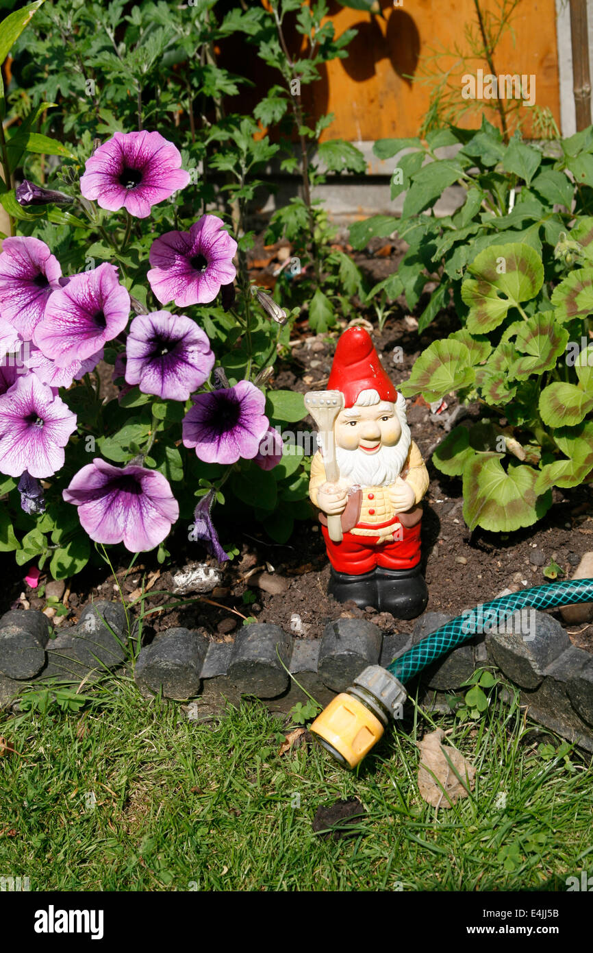 Garden Gnome avec tuyau de jardin et fleurs Worcester Worcester Worcestershre England UK Banque D'Images