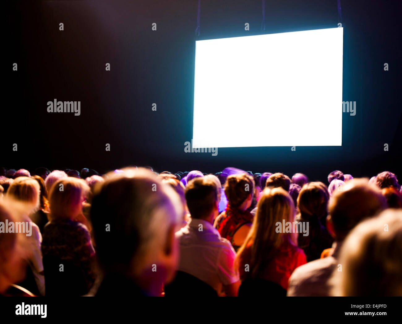L'auditoire dans le noir à la foule à l'écran lumineux Banque D'Images