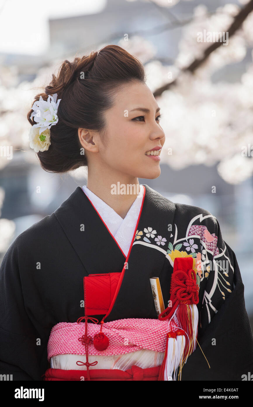 Jeune femme en kimono de mariage traditionnel au milieu de fleurs de cerisier dans le quartier Higashi Chaya de Kanazawa Banque D'Images