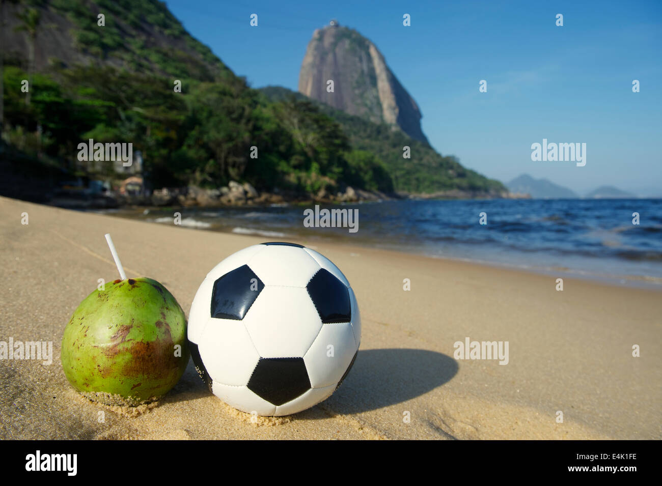Ballon de soccer Football debout à côté de frais vert coco Coco gelado potable Plage Rouge Mont Sugarloaf Rio de Janeiro Brésil Banque D'Images