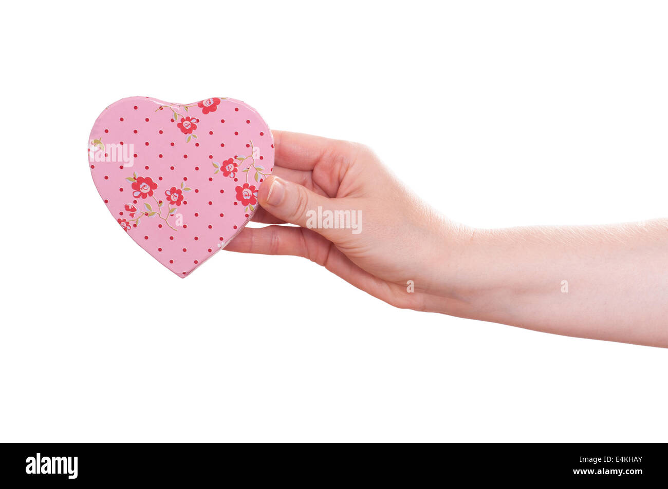 La main féminine est la tenue d'un coeur rose Banque D'Images