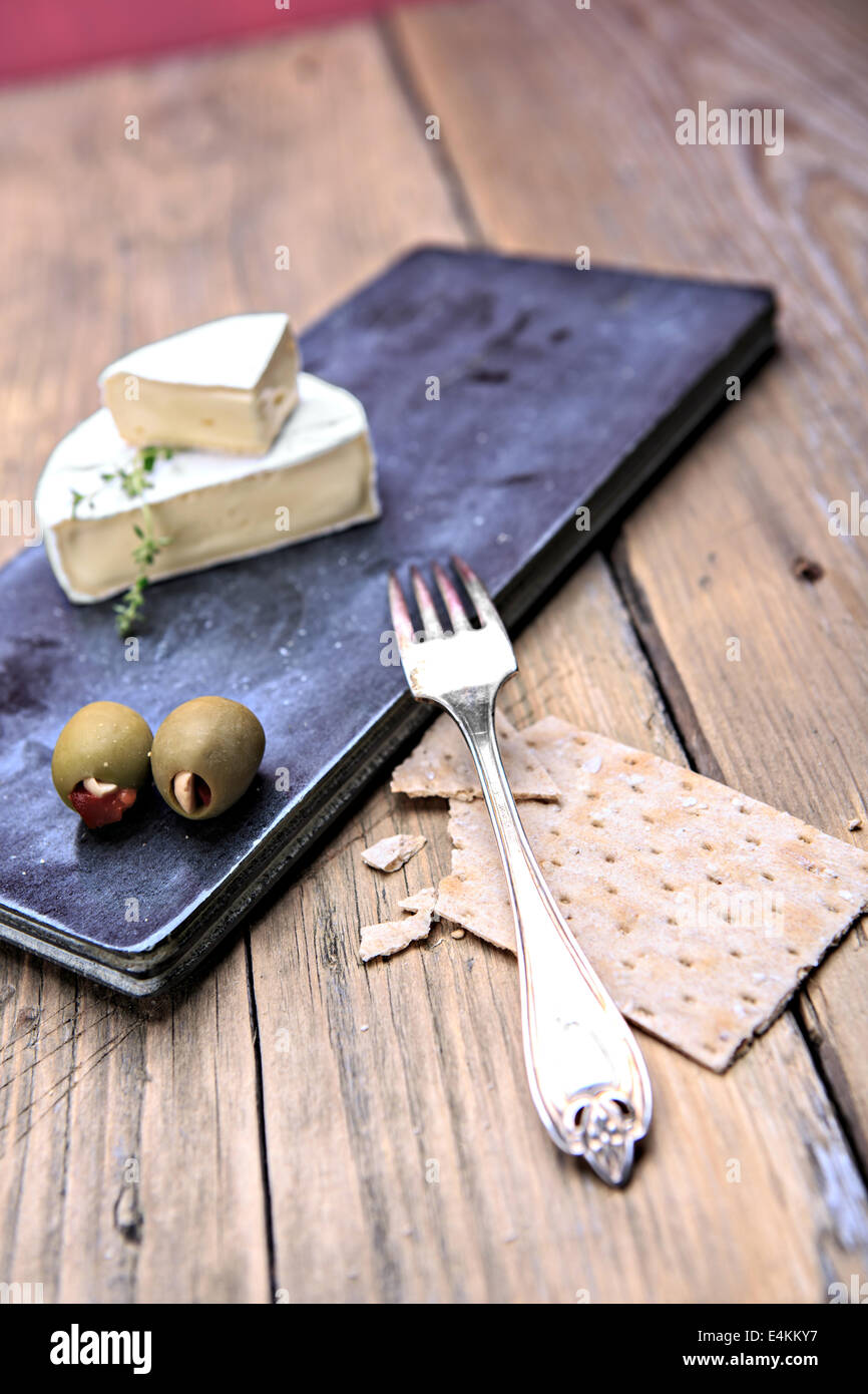 Nature morte avec assiette de fromage et les olives sur la table Banque D'Images
