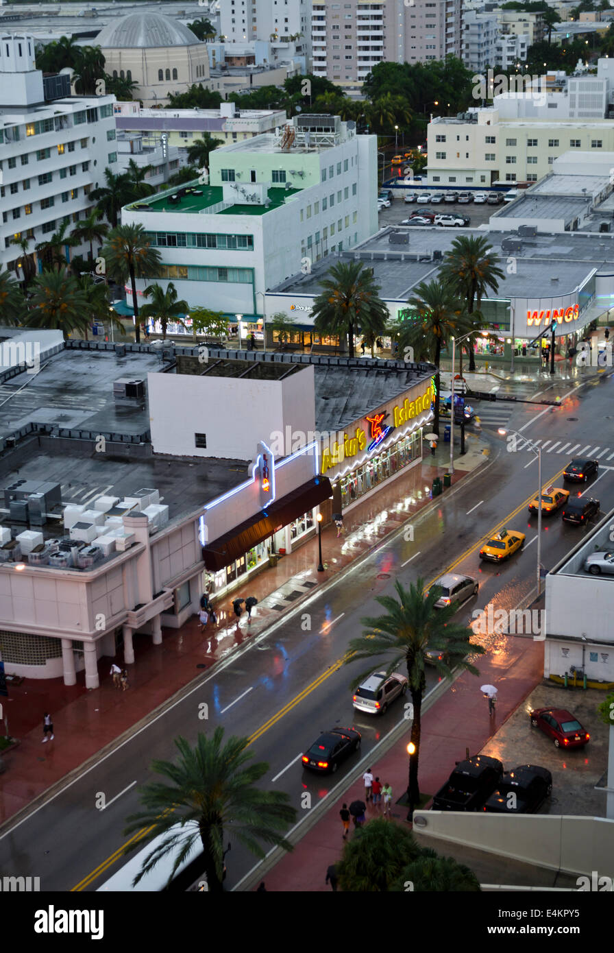 Vue de dessus de commerces, des bâtiments et des voitures sur l'avenue Collins, sur une sombre après-midi pluvieux à South Beach, Miami, Floride. Banque D'Images Vue de dessus de commerces, des bâtiments et des voitures sur l'avenue Collins, sur une sombre après-midi pluvieux à South Beach, Miami, Floride. Banque D'Images