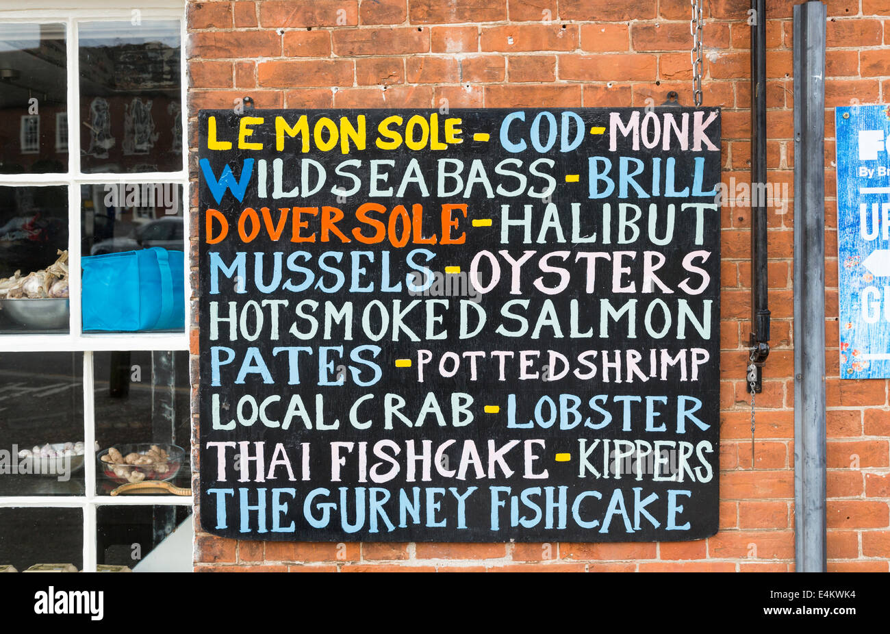 Civières poissonnerie, un poissonnier dans la petite ville de Burnham Market, North Norfolk, avec tableau noir coloré liste des fruits de mer Banque D'Images