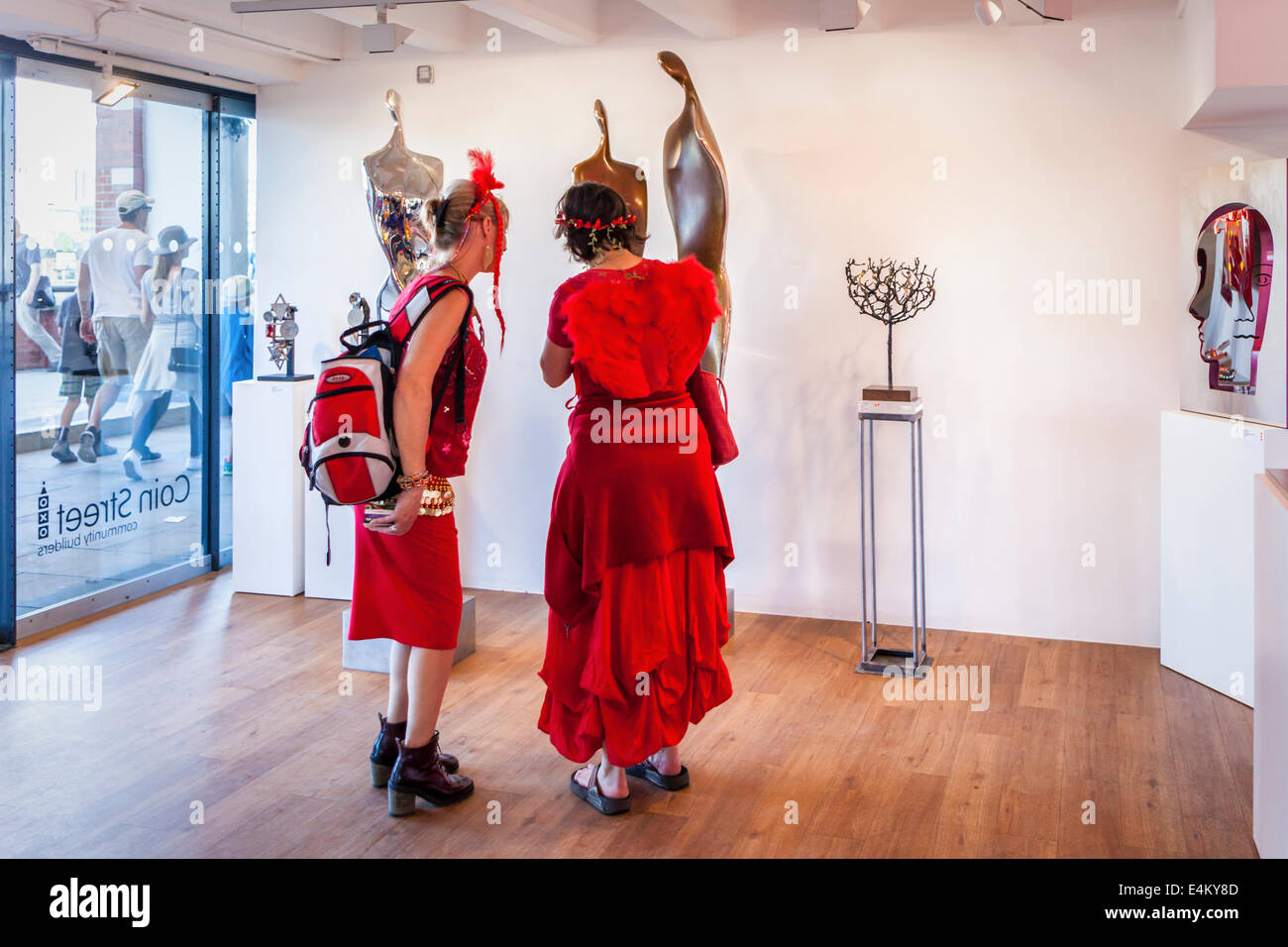 Mesdames habillés en vêtements rouges - les membres d'une chorale afficher les œuvres dans Coin Street Gallery, South Bank, Londres. UK Banque D'Images