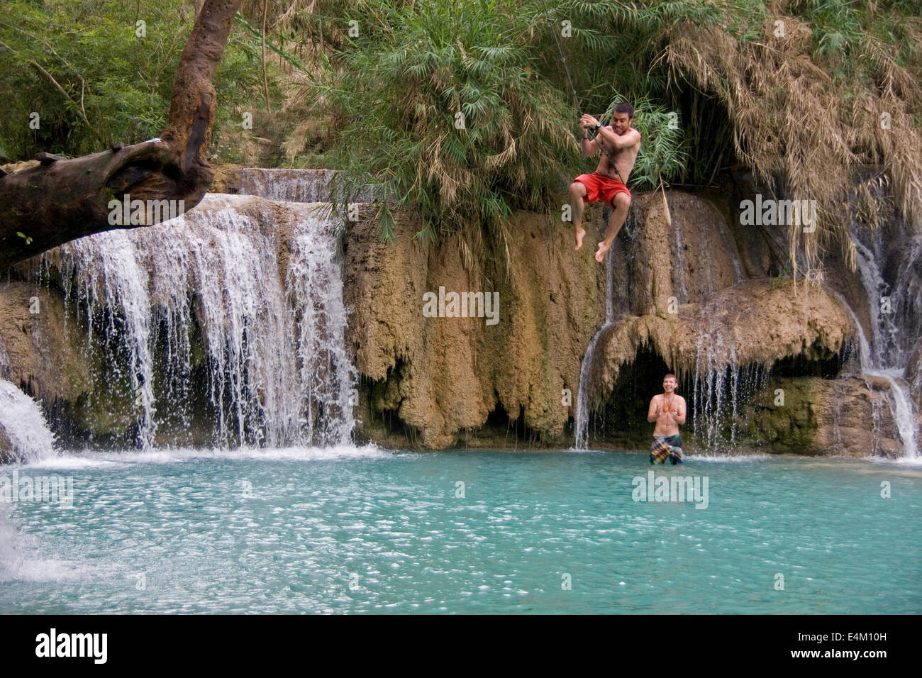 Les touristes à Kuang Si se balançant au dessus d'une piscine extérieure et de calcaire, près de Luang Prabang, Laos. Banque D'Images