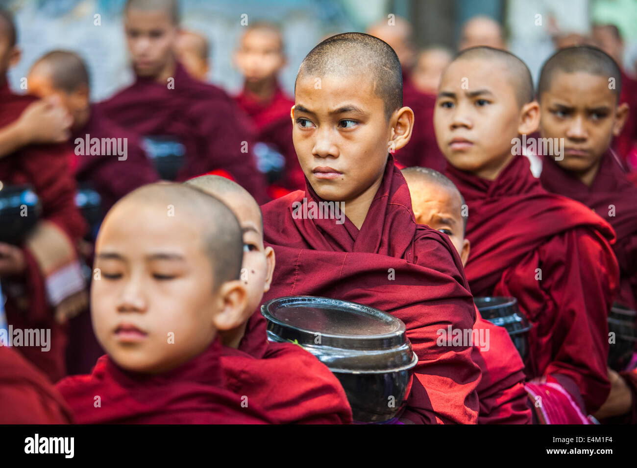 Les jeunes moines bouddhistes à attendre en ligne pour l'alimentation au cours d'une cérémonie à l'alms Maha Aung Mye Bonzan Monastery à Mandalay, Myanmar. Banque D'Images