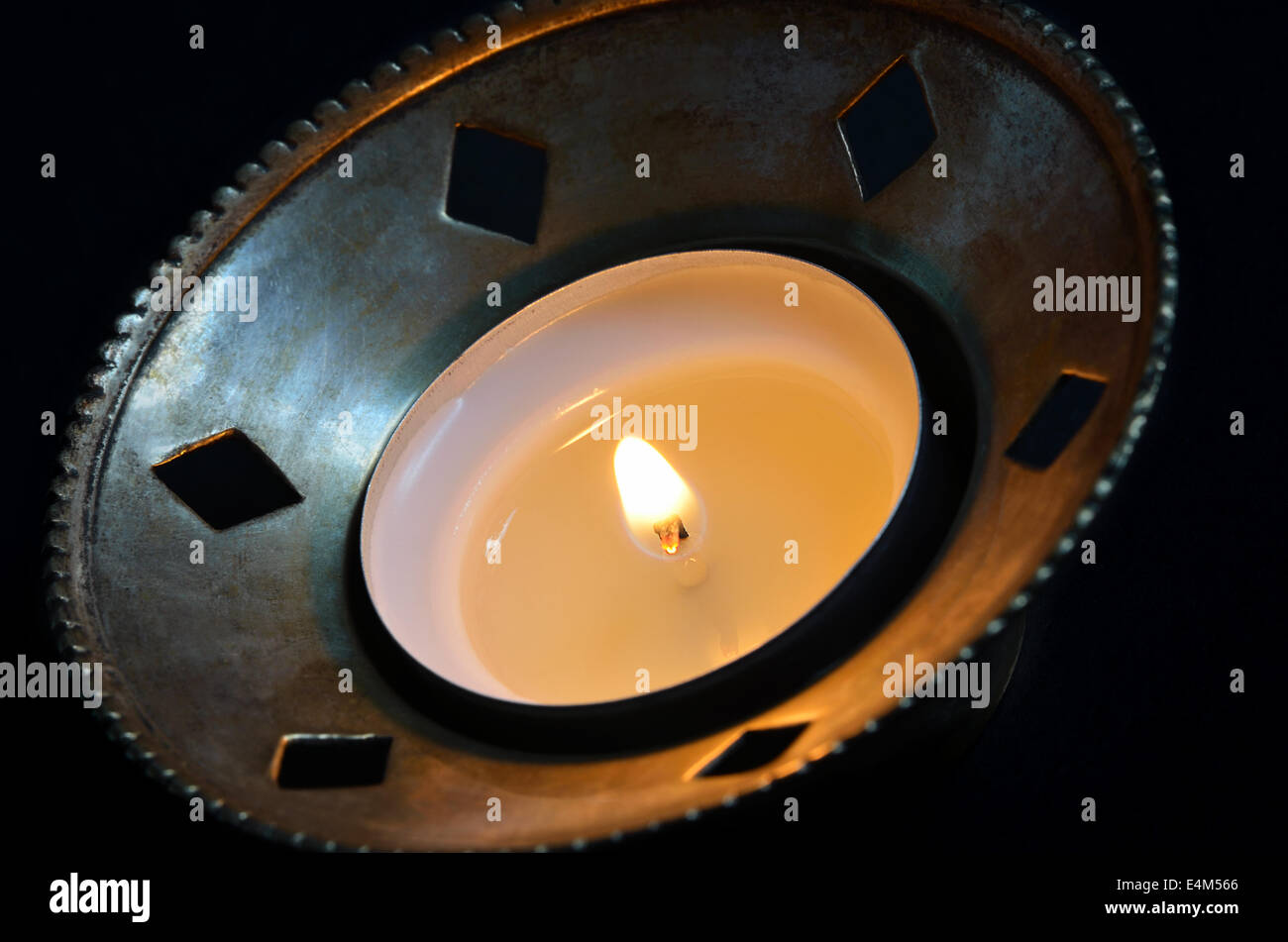 Le thé brûlant de lumière dans un chandelier d'argent, porte-close up, isolé sur fond noir Banque D'Images
