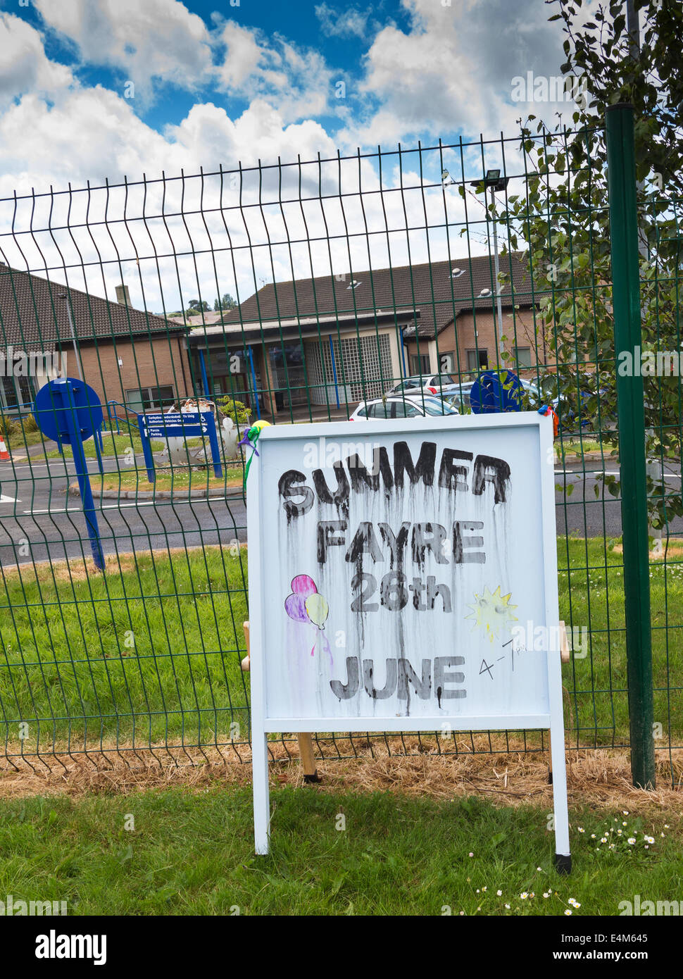 Un sale et imbibées d'eau signer une publicité lors d'une fête d'été avec l'école galloise rainclouds en arrière-plan. Typique d'un Brit Banque D'Images
