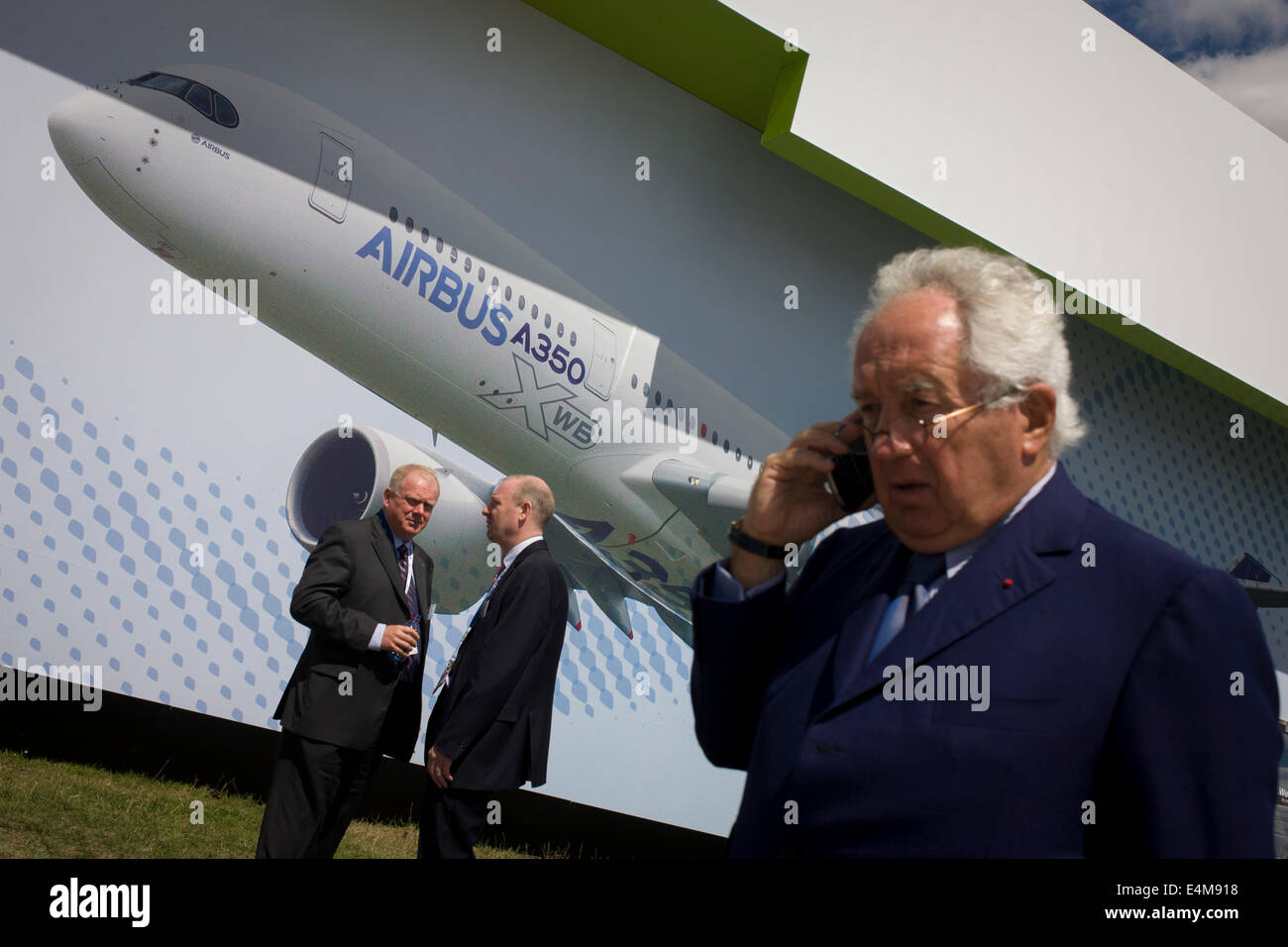 Les visiteurs sous un grand panneau publicitaire de l'Airbus A350 XWB sur le côté de l'Airbus Corporate chalet au salon de Farnborough, Angleterre. L'A350 XWB est le seul aéronef tout-nouveau dans la catégorie siège 400. L'A350 XWB est une famille de longue distance, deux gros-porteurs à moteur des avions de ligne à réaction développé par l'avionneur européen Airbus. L'A350 est le premier Airbus avec les structures de l'aile et de fuselage fait principalement de carbone-fibre de polym Banque D'Images