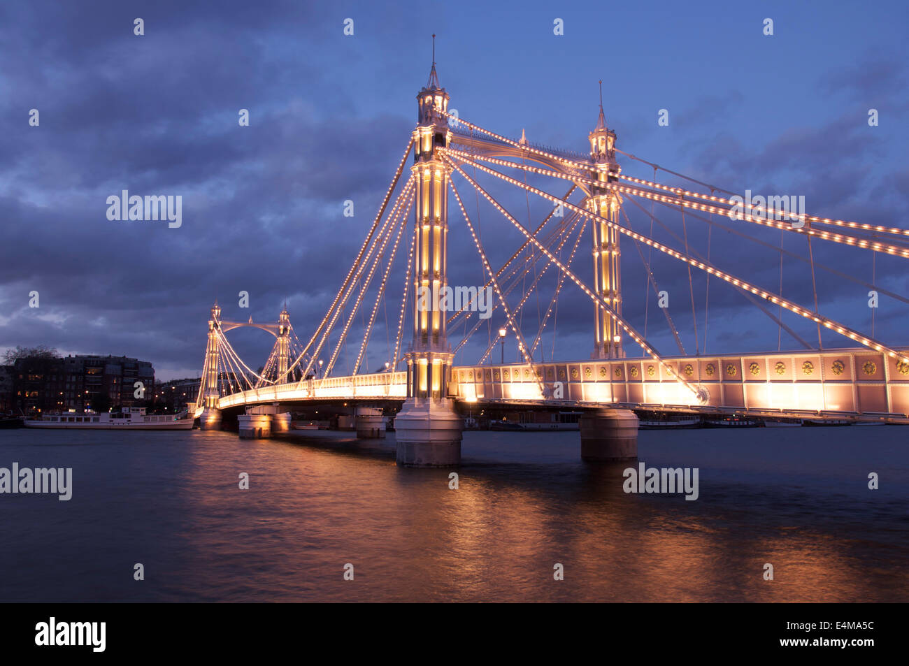 La lumineuse splendeur victorienne d'Albert Bridge, allumé à la tombée de la nuit, en traversant la Tamise entre Battersea et Chelsea. Londres, Angleterre. UK. Banque D'Images