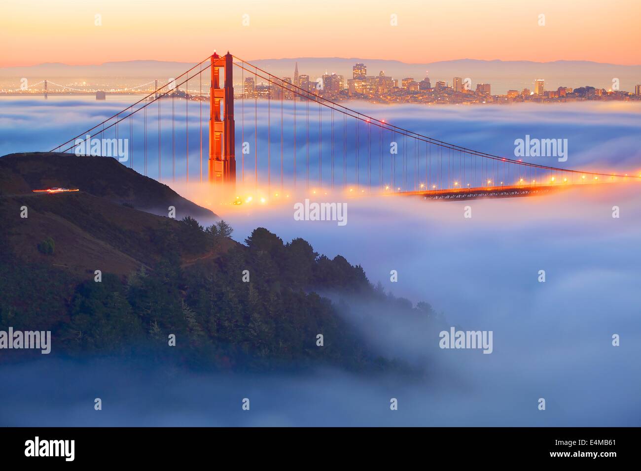 Golden Gate Bridge et l'horizon de San Francisco dans le brouillard au lever du soleil Banque D'Images