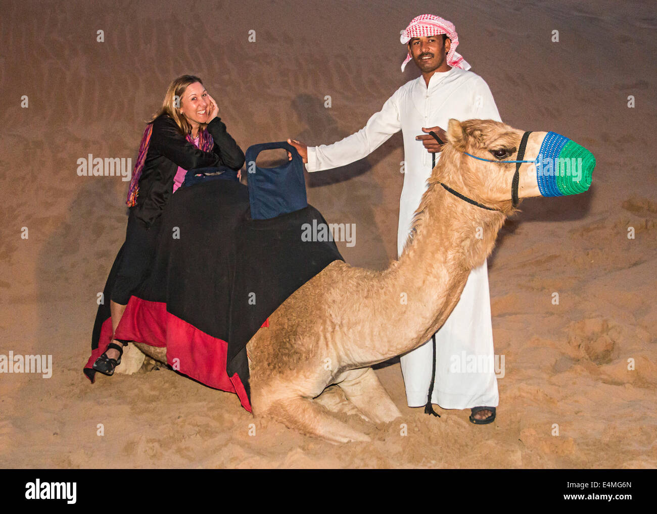 L'équitation de chameau au camp Bédouin au cours de safari dans le désert à Dubaï, Émirats arabes unis. Banque D'Images