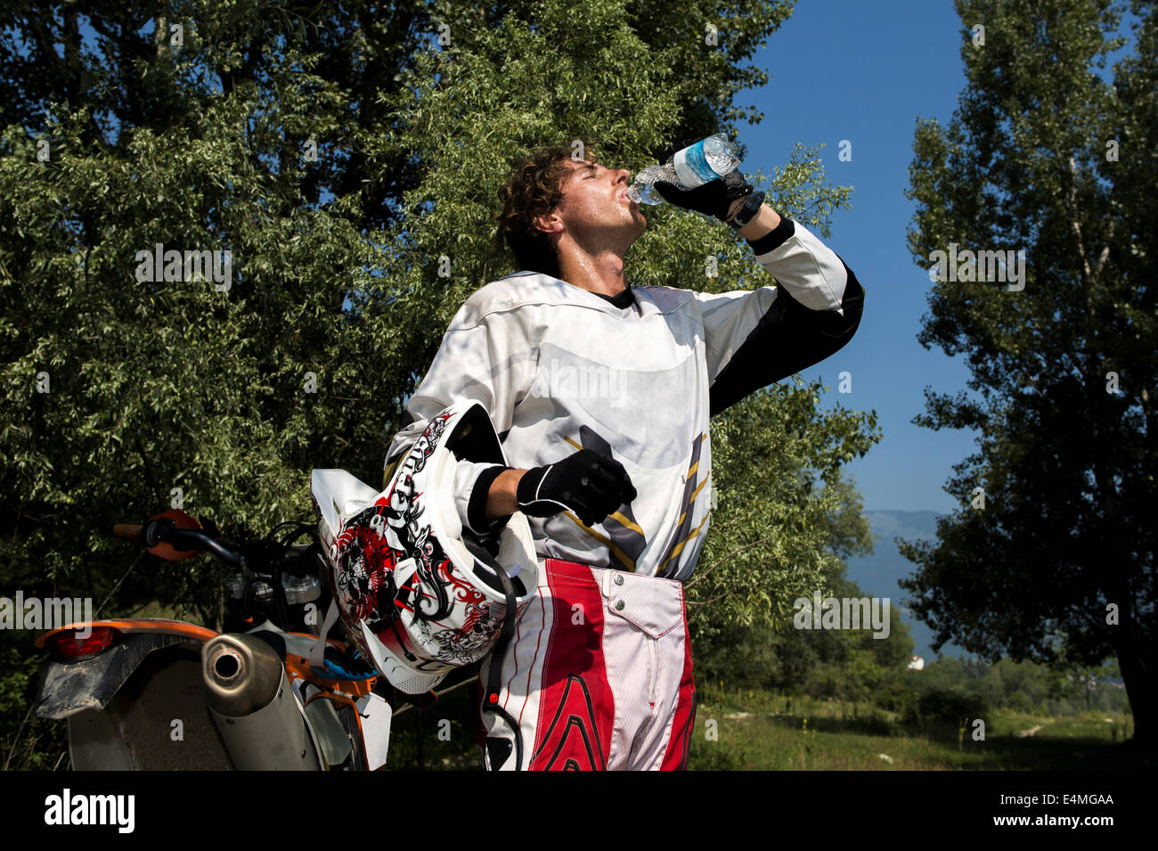 Jeune homme se détendre après Dirt Bike Ride Banque D'Images