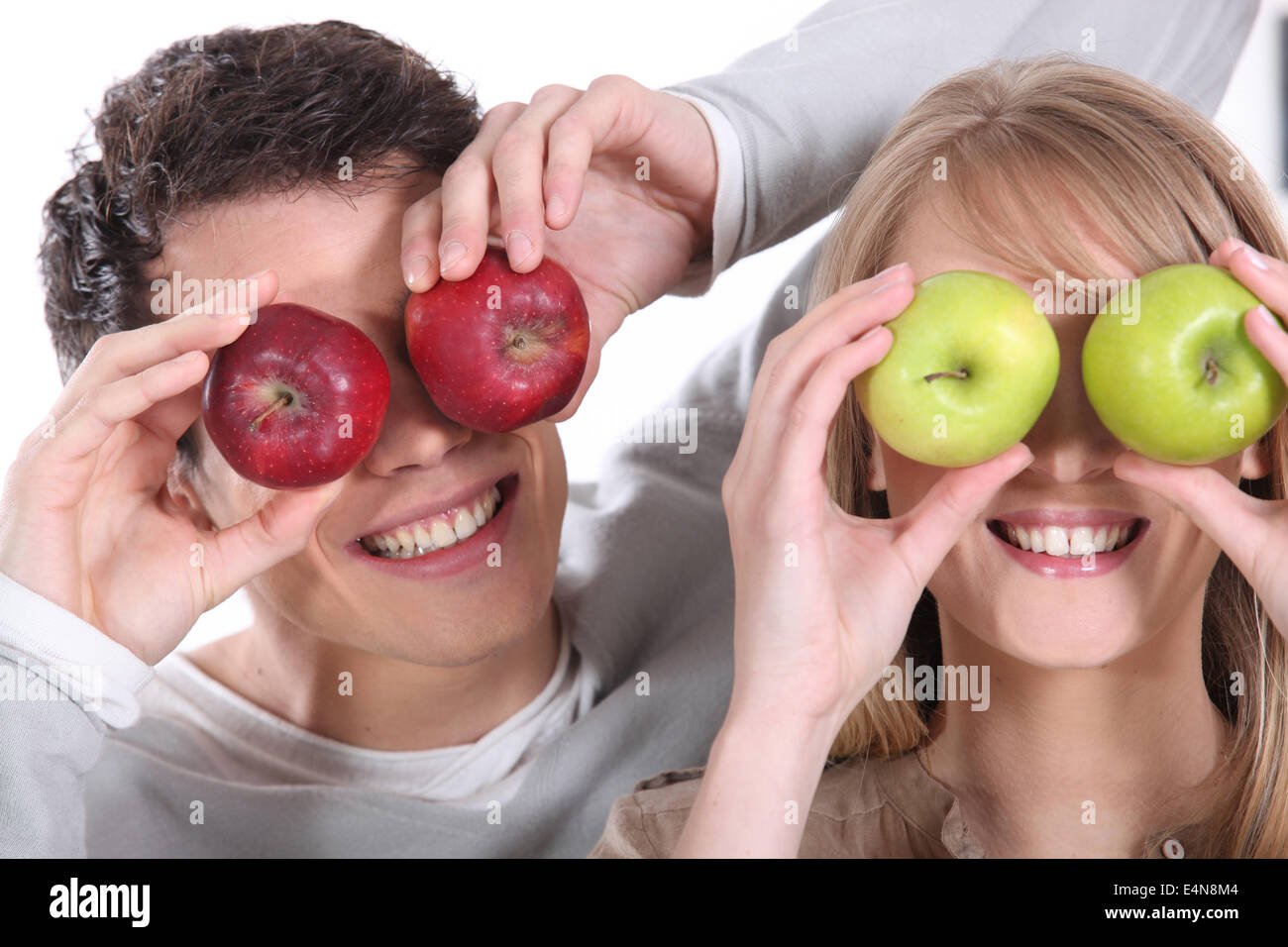 L'homme et de la femme couvrant ses yeux avec des pommes Banque D'Images